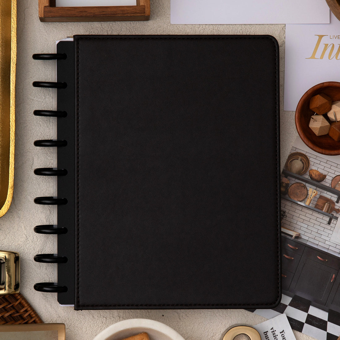 brown faux leather cover with black disc on this inkwell planner surrounded by office supplies